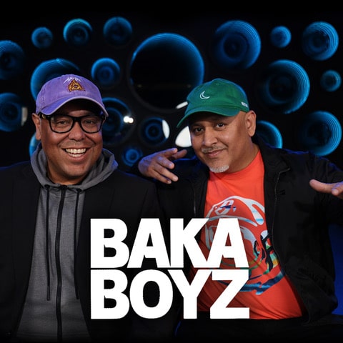 Nick and Eric Vidal, hosts of The Baka Boyz Daily radio show, smiling in studio with speaker wall backdrop